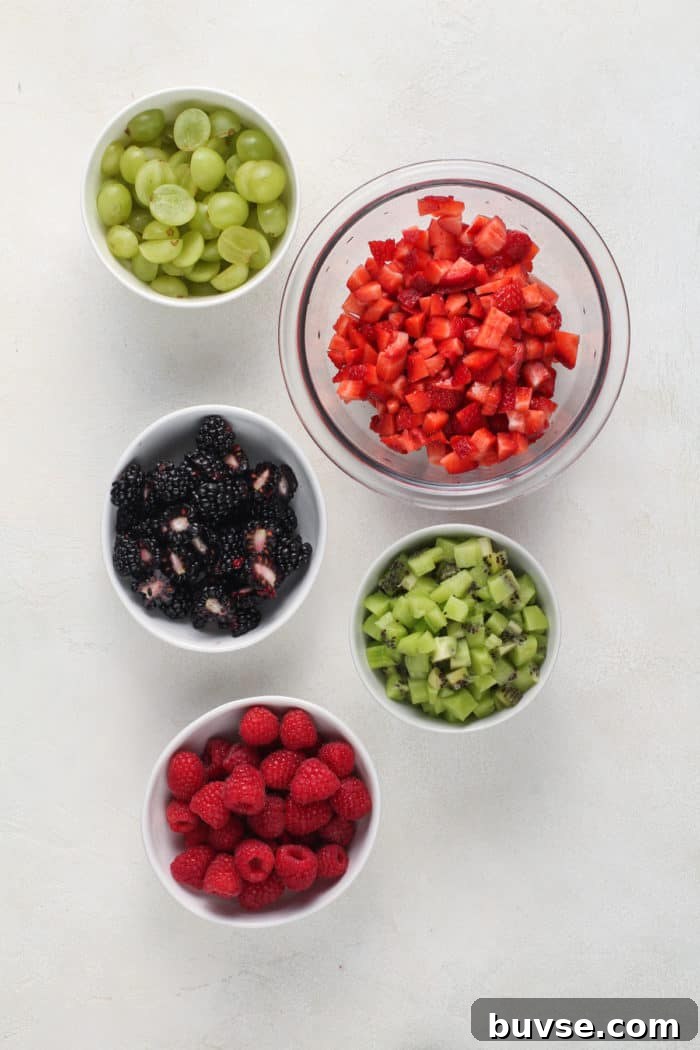 Fresh Fruit Salsa Recipe with Lime and Cilantro 5 Bowls of diced fresh fruit for fruit salsa arranged on a white countertop.