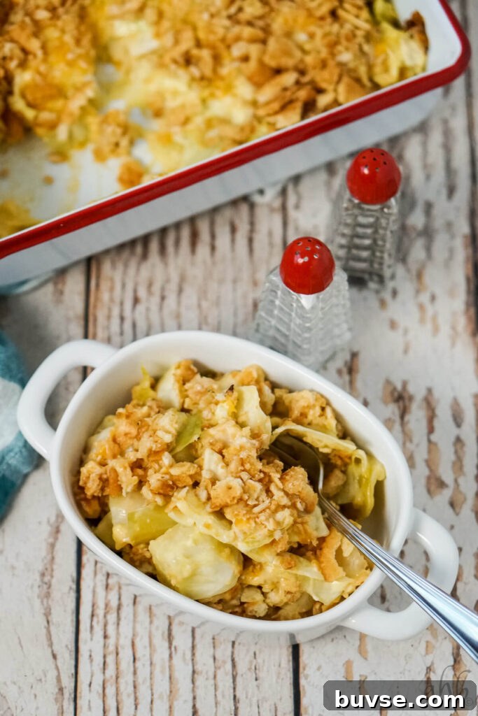 A bowl with a serving of Scalloped Cabbage Casserole next to salt and pepper shakers