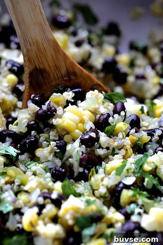 Photo of the filling of corn, black beans and rice being stirred with wooden spoon.