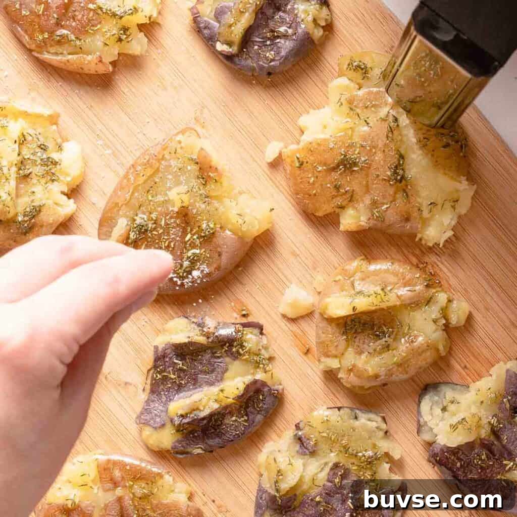 salt being sprinkled on smashed potatoes before air frying.