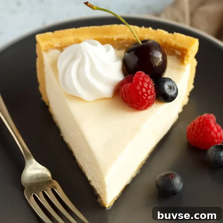 A slice of no bake vanilla cheesecake on a grey plate with a fork, topped with mixed berries