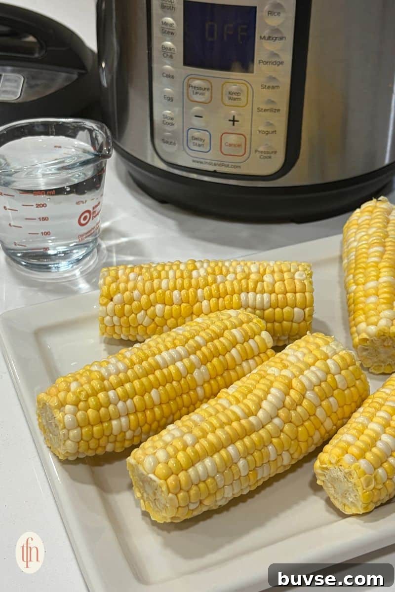 corn on the cob resting on a white serving tray.
