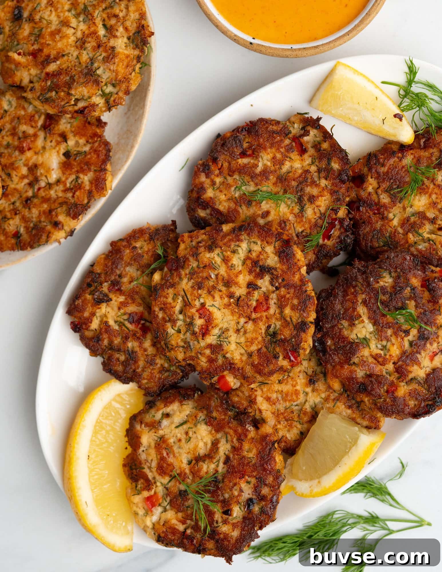 Crispy Homemade Salmon Patties with Lemon Dill Sauce 8 Plate of crispy salmon patties.