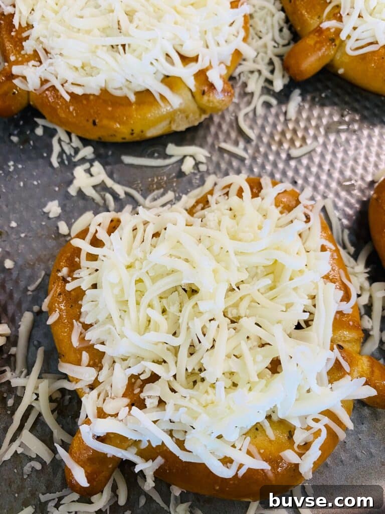 topping the soft pretzels with cheese