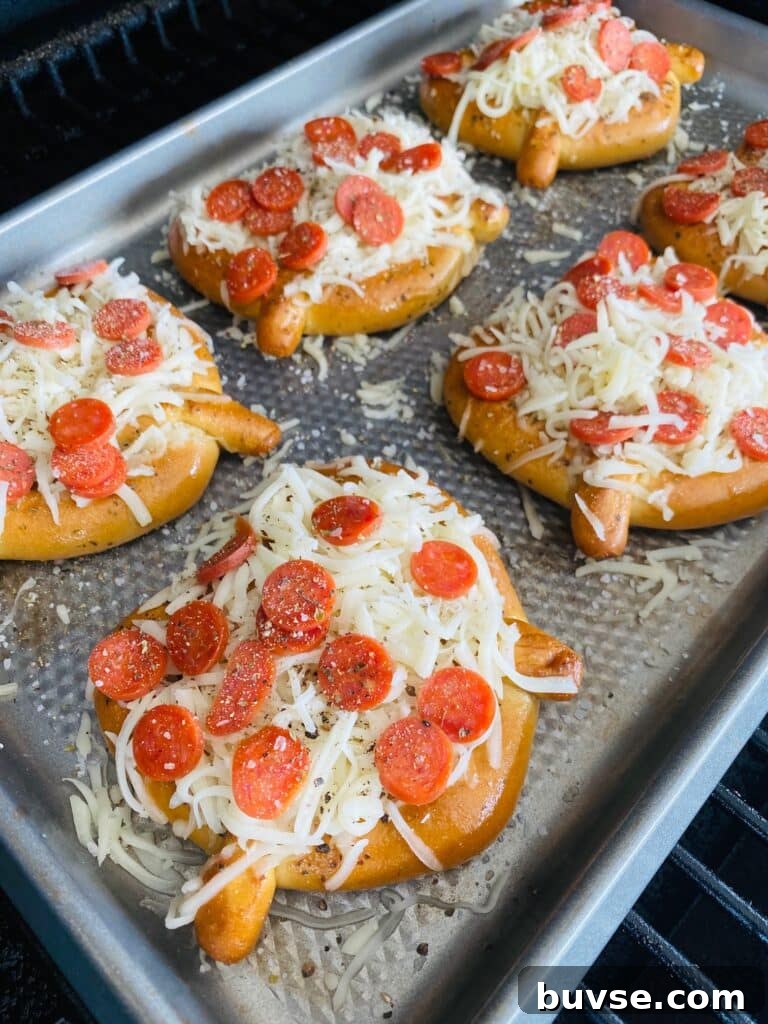 soft pretzel pizzas topped with pepperoni on the smoker