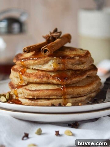 Chai pancakes stacked with cinnamon and maple syrup.