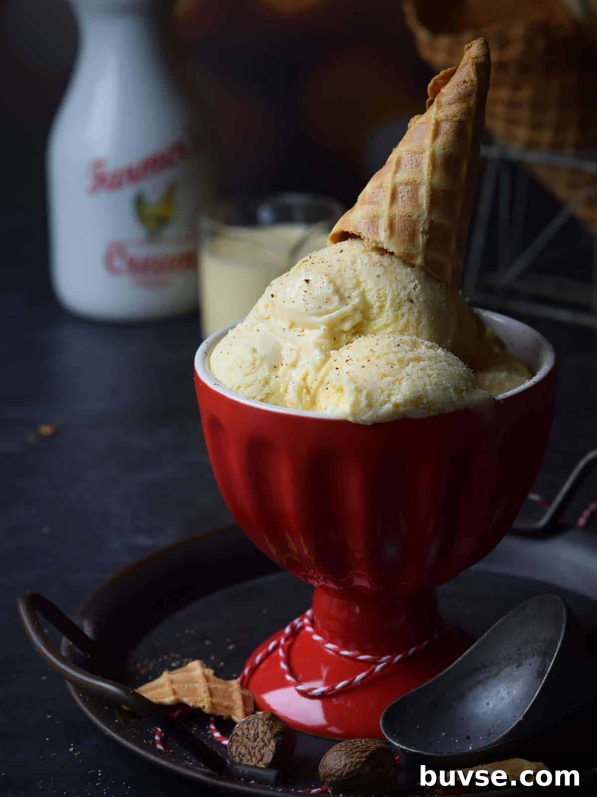 Ice cream in a red cup with an ice cream cone on top.