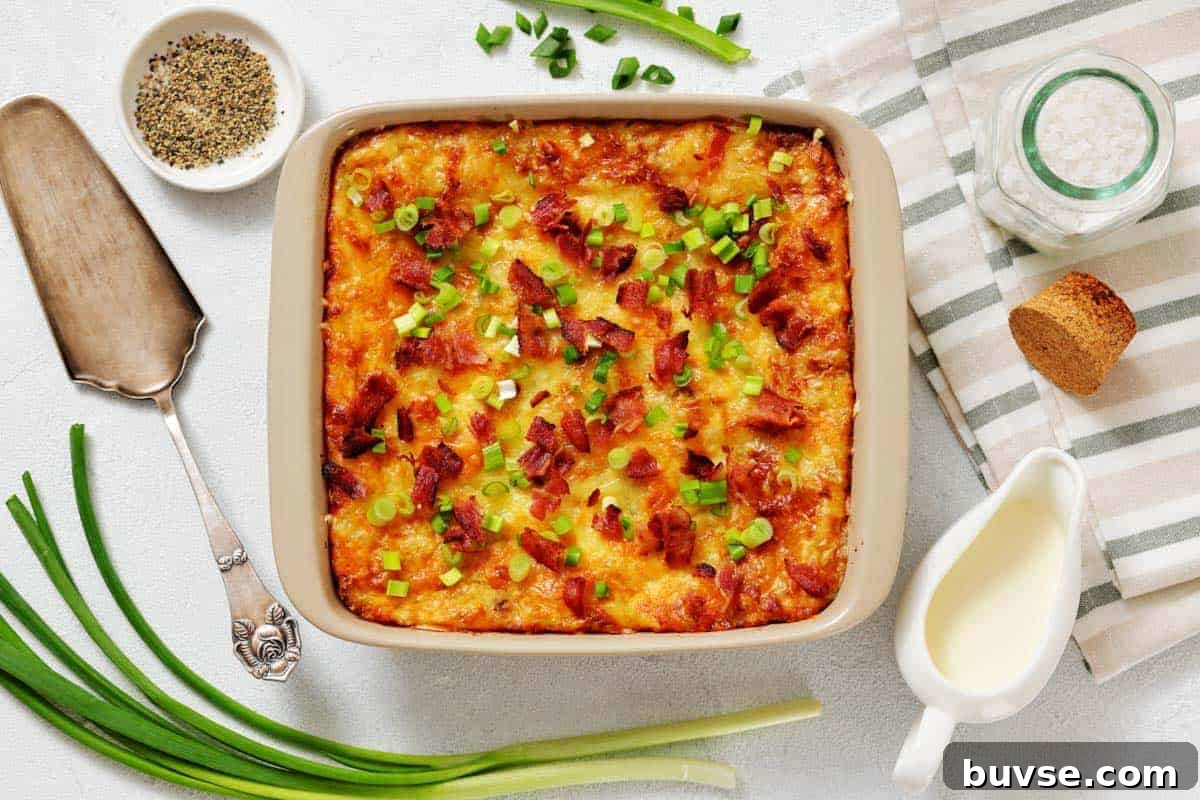 Grandma’s Twice-Baked Potato Casserole topped with chopped green onions and bacon, surrounded by fresh green onions.