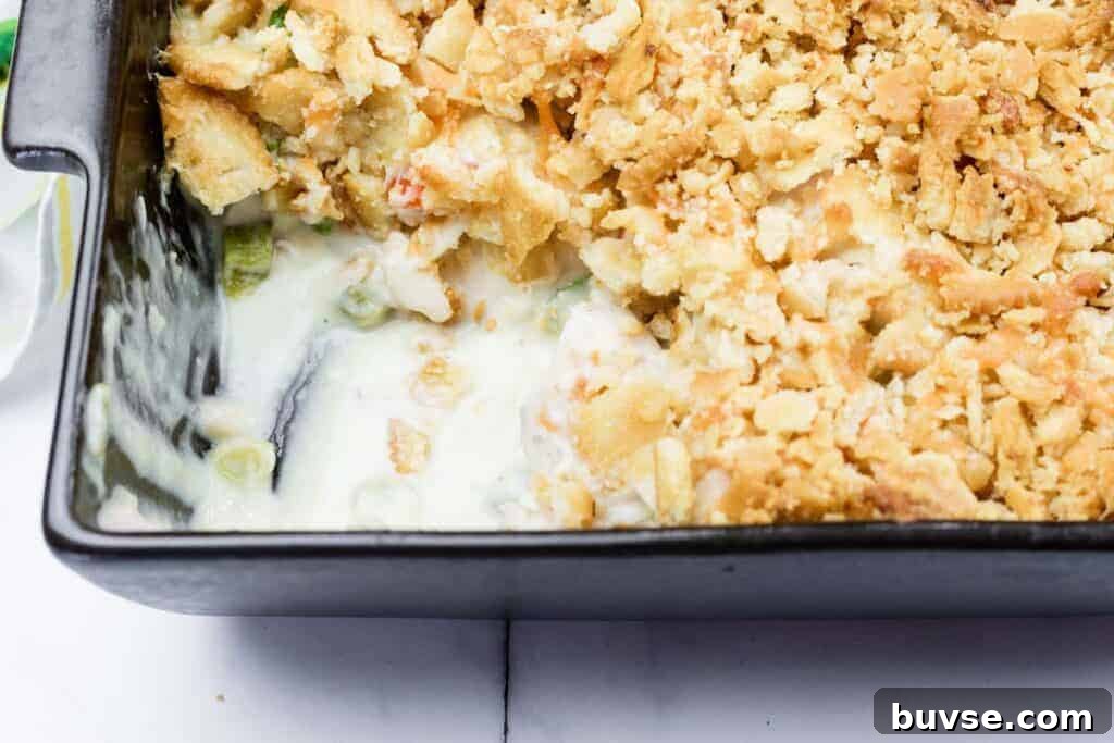 A close-up of a Cheesy Ritz Cracker Chicken Casserole dish with a portion missing from one side.