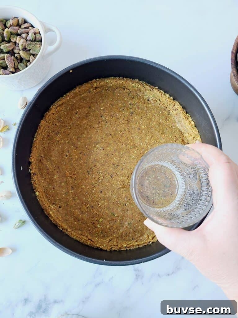 Tapping with glass the mixture for graham cracker's crust into a pan
