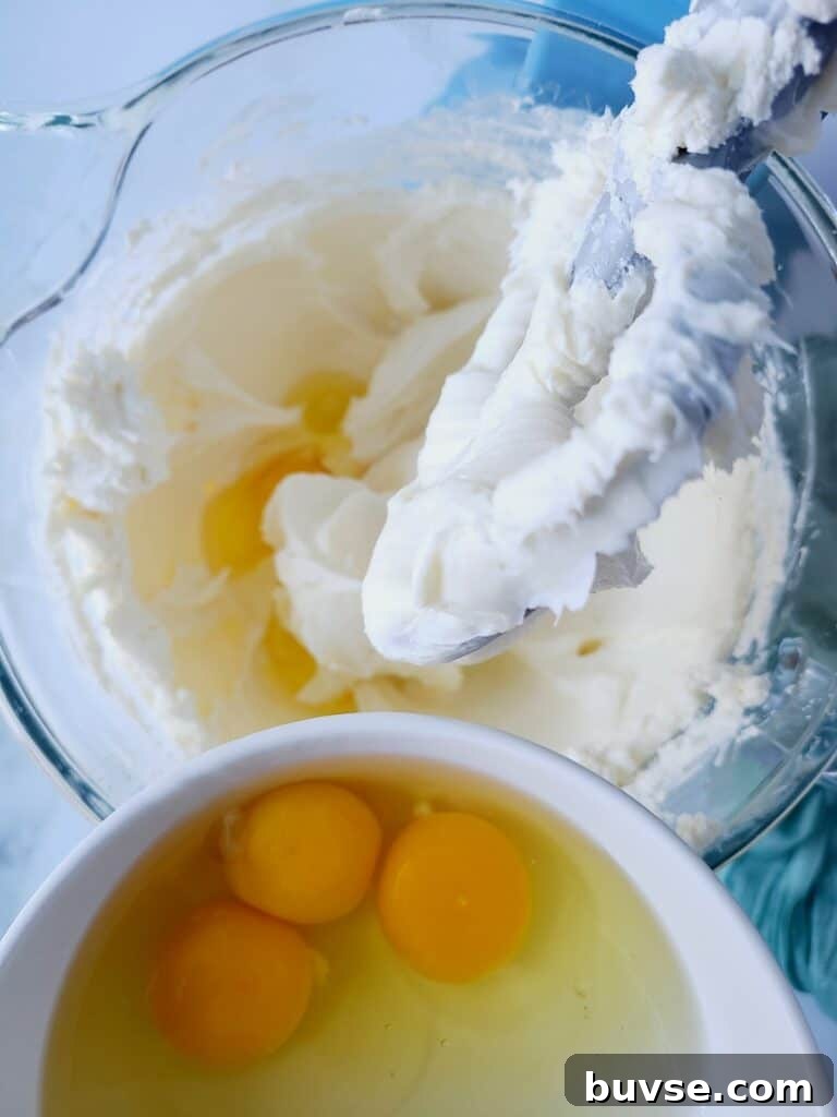 Mixing eggs into cheesecake batter