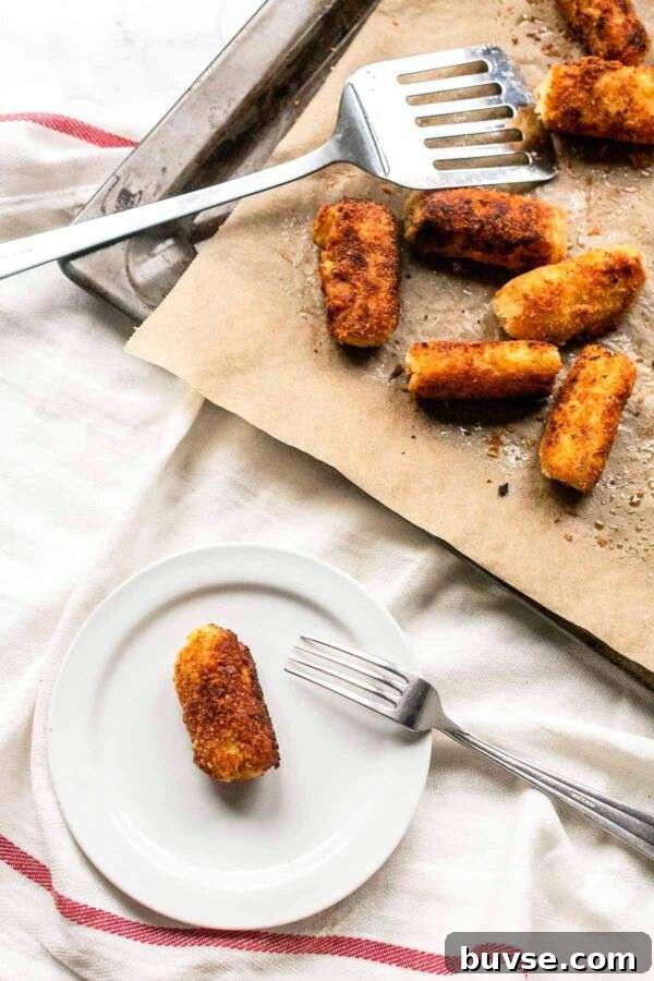 Crispy Potato Croquettes Recipe for Golden Homemade Bites 5 Oven baked potato croquette on a white plate. Ready to be served as a side dish.