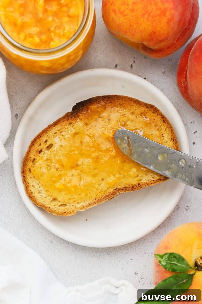 spreading peach freezer jam on a slice of gluten-free toast