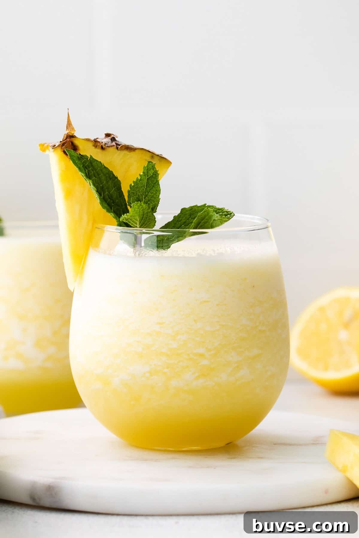 a glass of lemonade with a pineapple garnish.