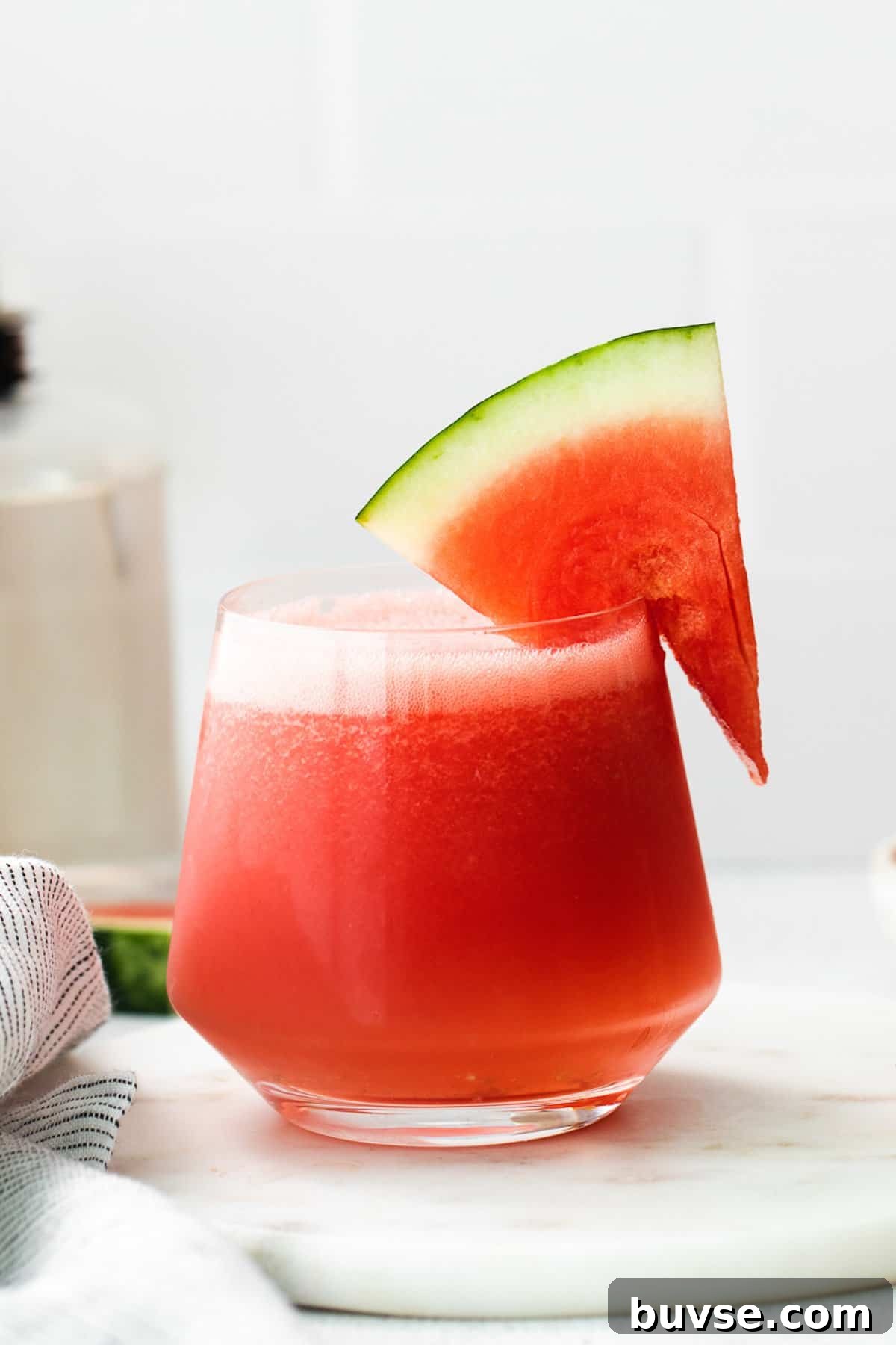 a watermelon drink in a glass with a slice of watermelon on.