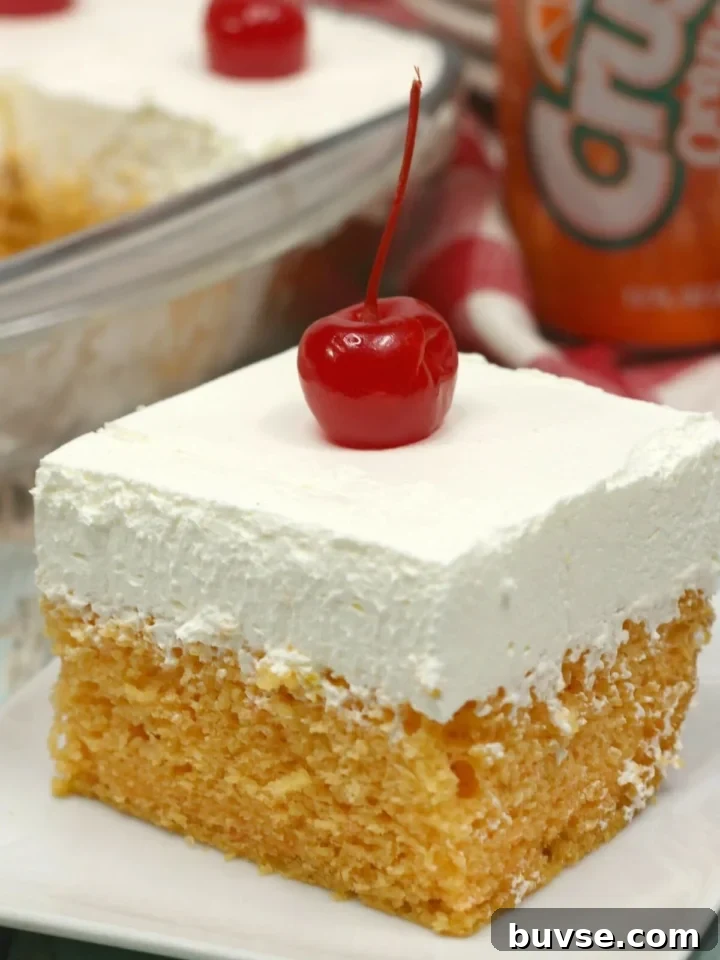Slice of orange crush cake topped with a cherry