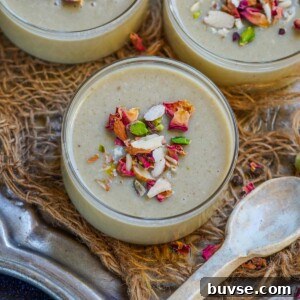 Three small glass bowls of creamy Paan Panna Cotta, garnished with chopped nuts and dried rose petals.