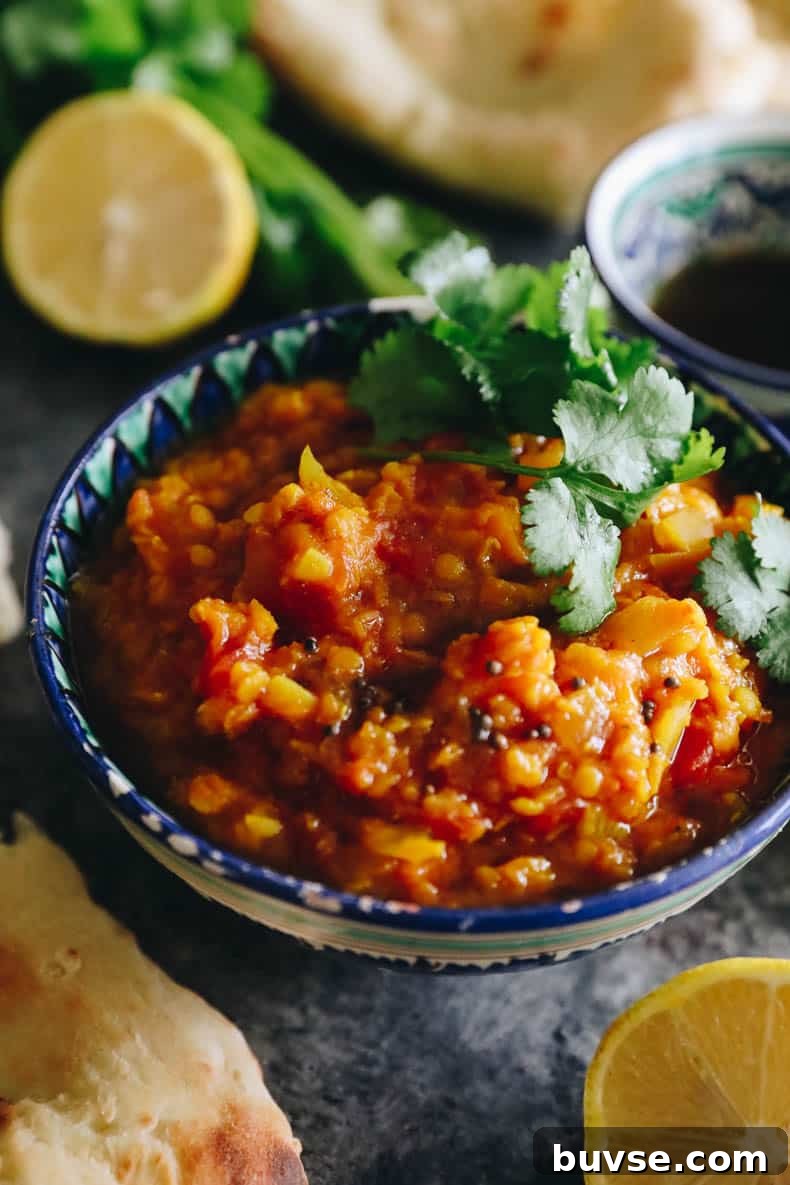 close-up image of root vegetable dal topped with spice oil and cilantro.