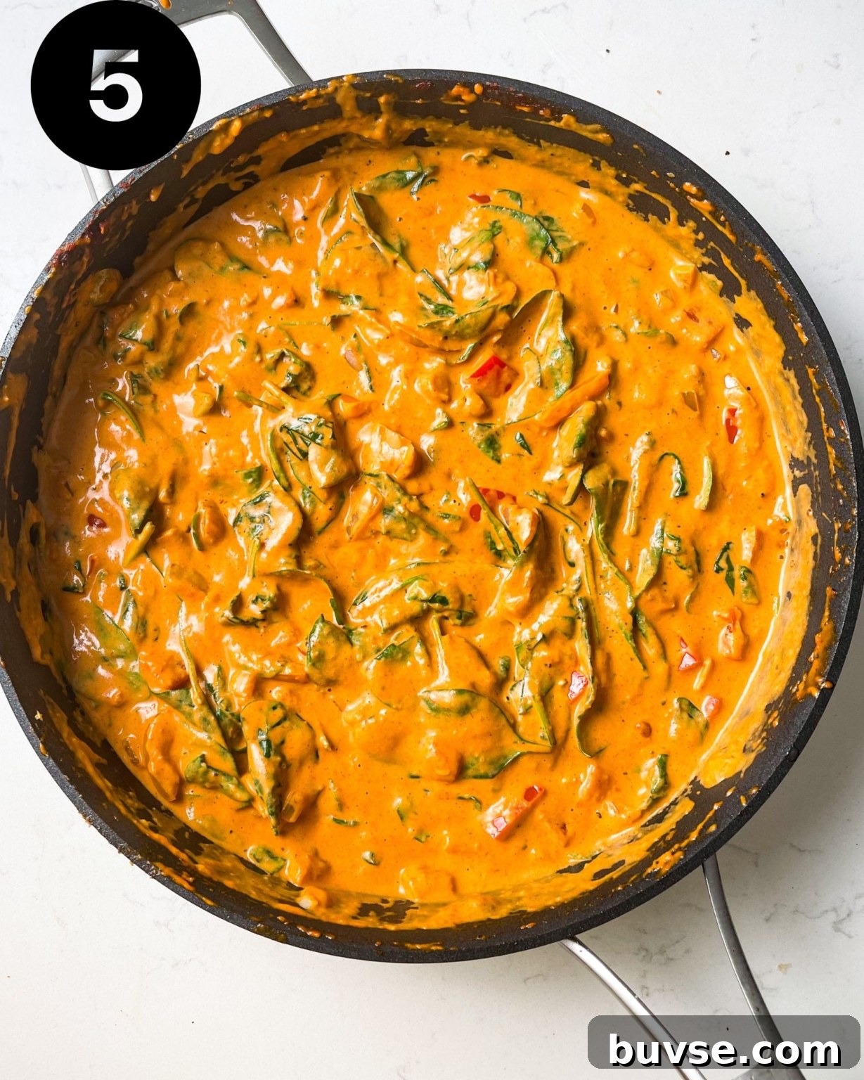 creamy cajun pasta sauce in a pan with spinach.