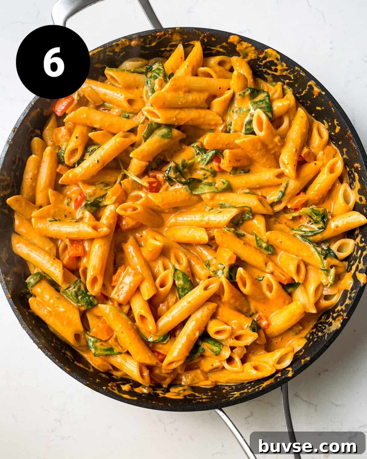 pasta added to the creamy cajun sauce in a large skillet.