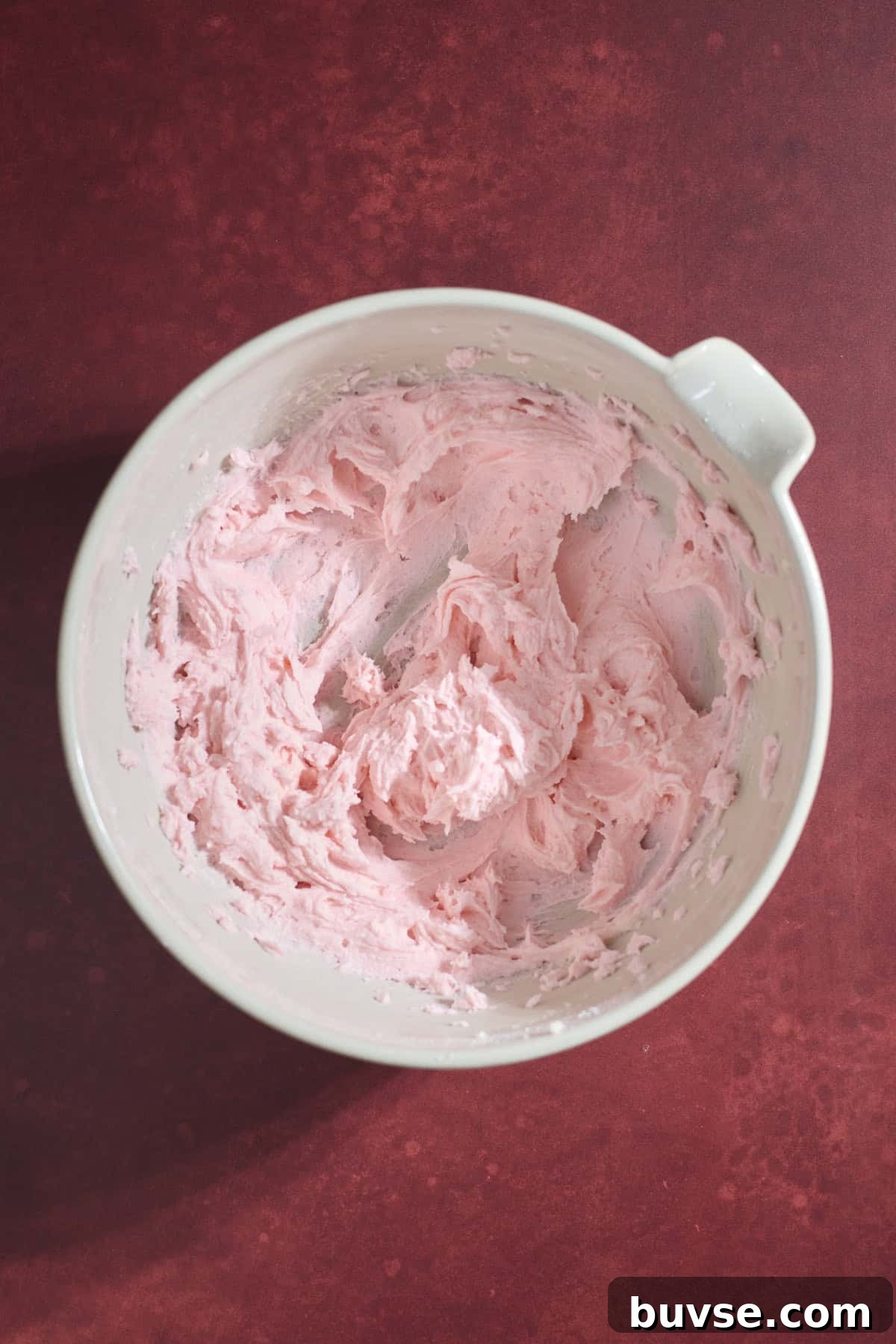 Pink frosting in a bowl.