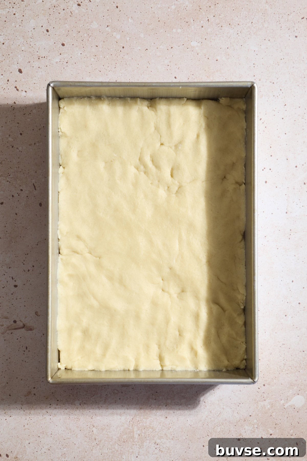 Cookie dough pressed into a 9x13-inch baking pan.