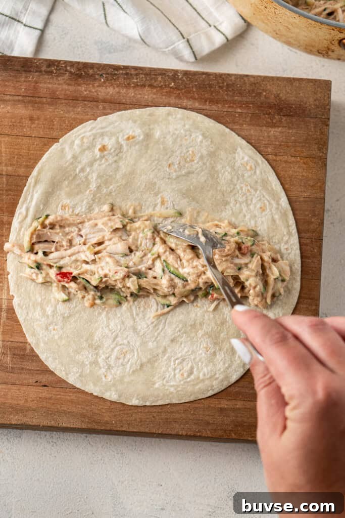 Flavorful Dairy-Free Chicken Enchiladas Recipe 9 Placing the filling into the flour tortilla.