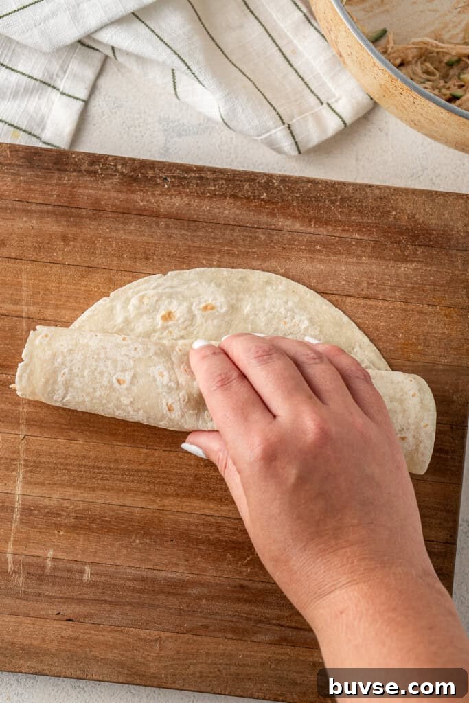 Flavorful Dairy-Free Chicken Enchiladas Recipe 10 Rolling up the tortilla.