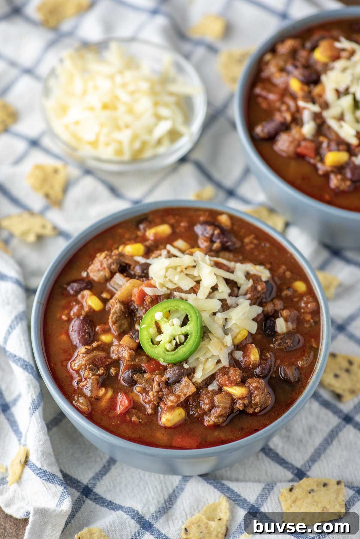 beef chili in two blue bowls on dish towel