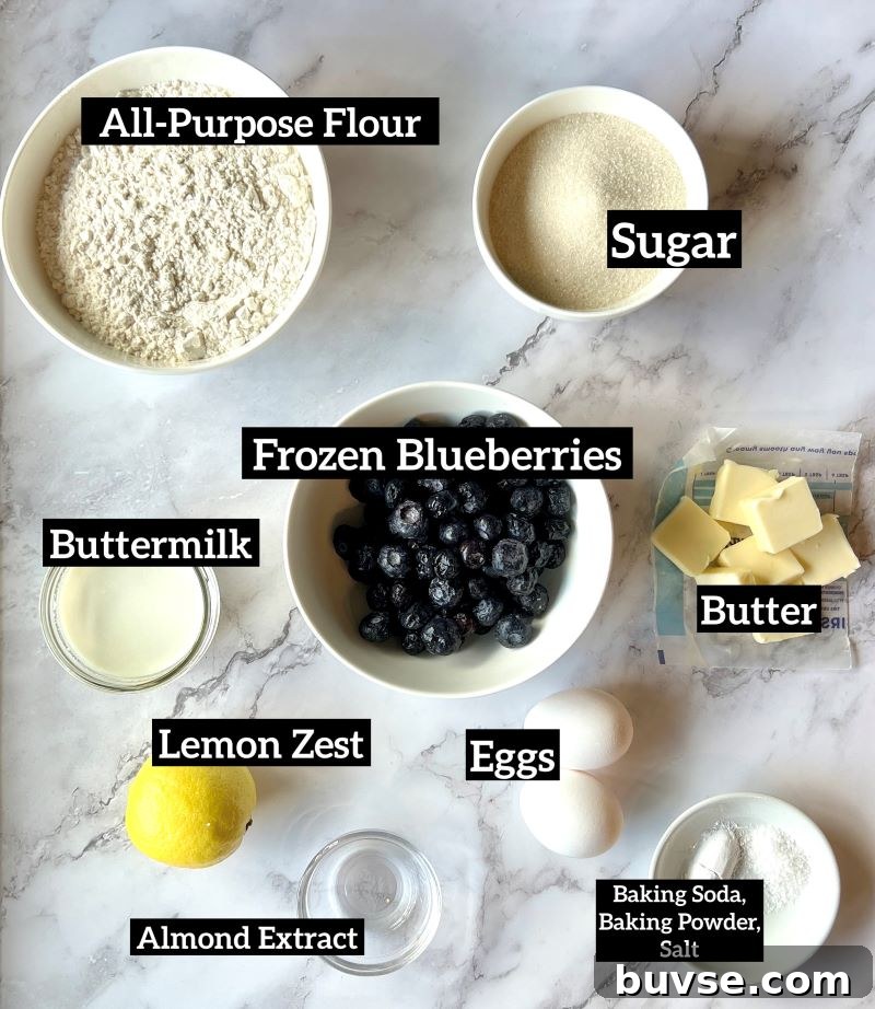 Ingredients for blueberry buckle set out. Flour, baking soda, baking powder, lemon zest, sugar, butter, eggs, almond extract, buttermilk, frozen blueberries. 
