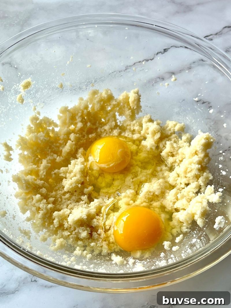 Butter, sugar, eggs, and almond extract mixed in a separate bowl