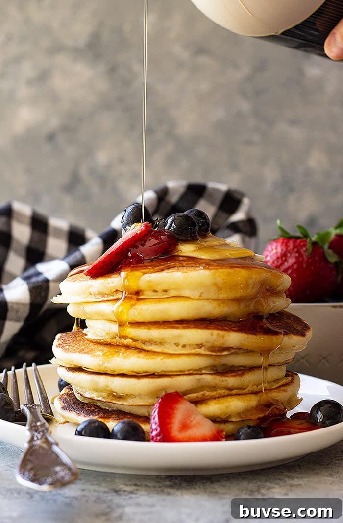 Pantry Recipes: Creative Shelf Cooking with Staples 6 Tall stack of Fluffy Buttermilk Pancakes topped with fresh berries and being drizzled with syrup.