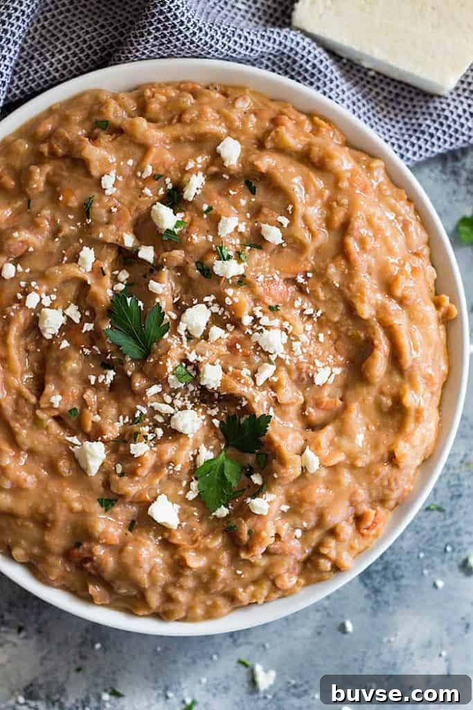 Pantry Recipes: Creative Shelf Cooking with Staples 55 Overhead shot of a bowl of refried beans sprinkled with cheese.