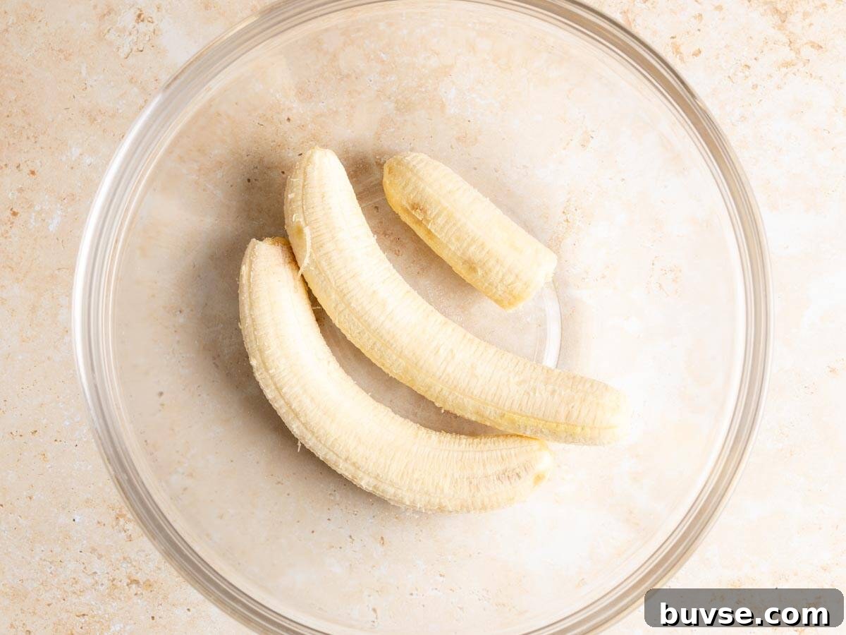 One-Bowl Brown Butter Mochi Banana Bread Recipe 5 Bananas in a glass bowl.