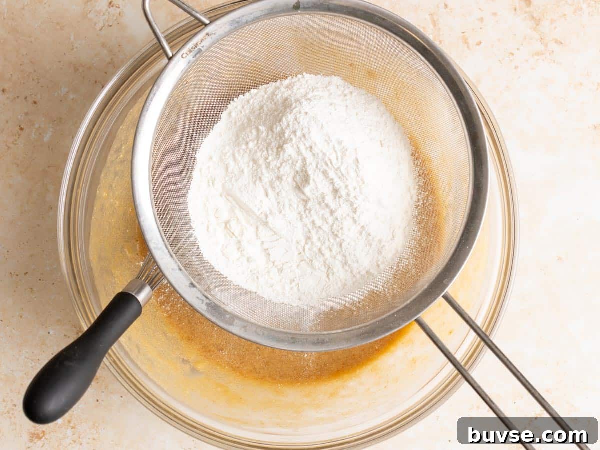 One-Bowl Brown Butter Mochi Banana Bread Recipe 8 Flour is being sifted through a seive.