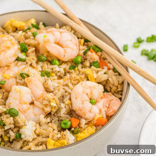 Leftover Shrimp Recipes: 12 Flavorful Ideas 5 Shrimp fried rice in a bowl with chopsticks.