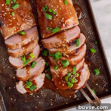 Overhead view of teriyaki pork tenderloin on a sheet pan.