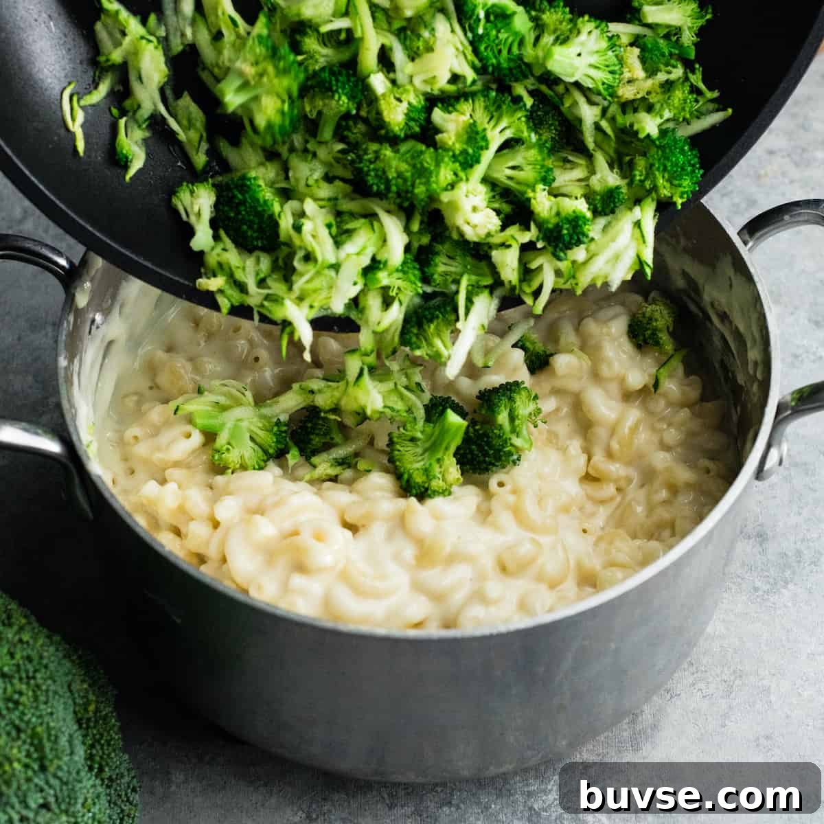 veggies being added to mac and cheese