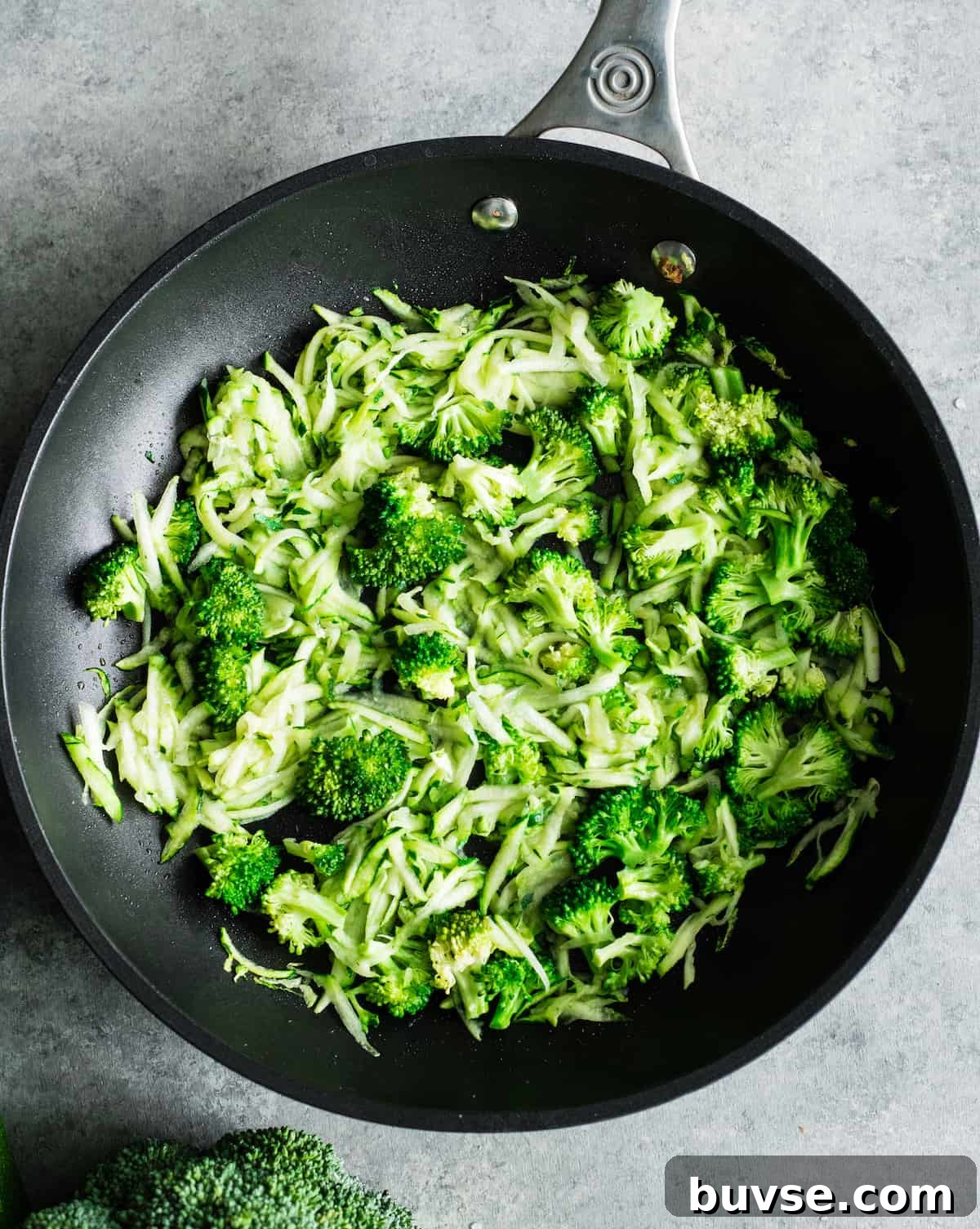 zucchini and broccoli cooking in a pan