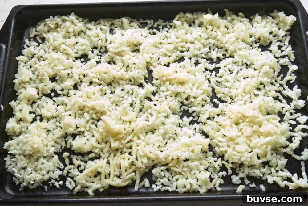 Riced potatoes cooling on a sheet pan.