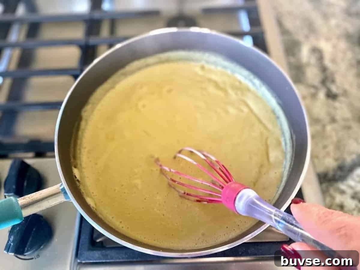 Creamy Vegan White Sauce Lasagna Recipe 6 I am whicking the white sauce in the saucepan so it thickens.