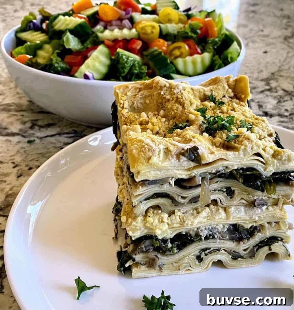 Creamy Vegan White Sauce Lasagna Recipe 10 Vegan white lasagna served on a plate on the table with a salad.