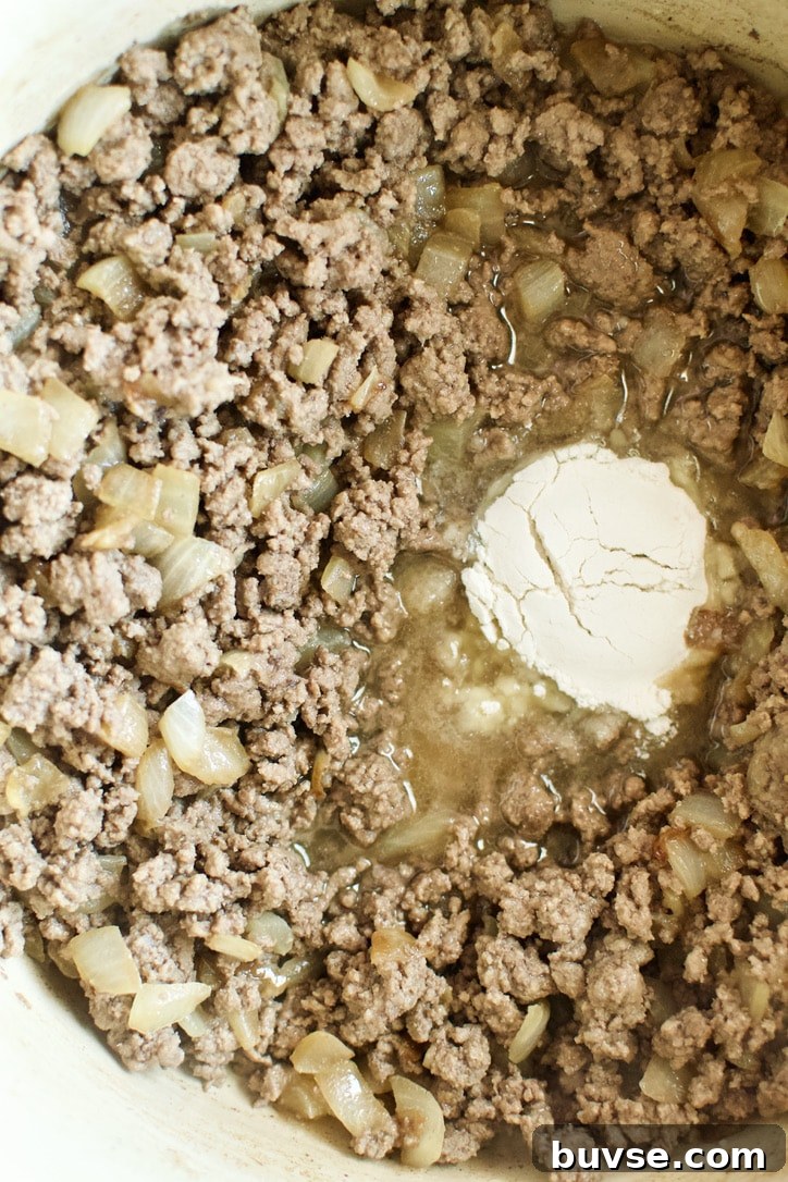 Ground beef added to the pot, browned and flour added to thicken.