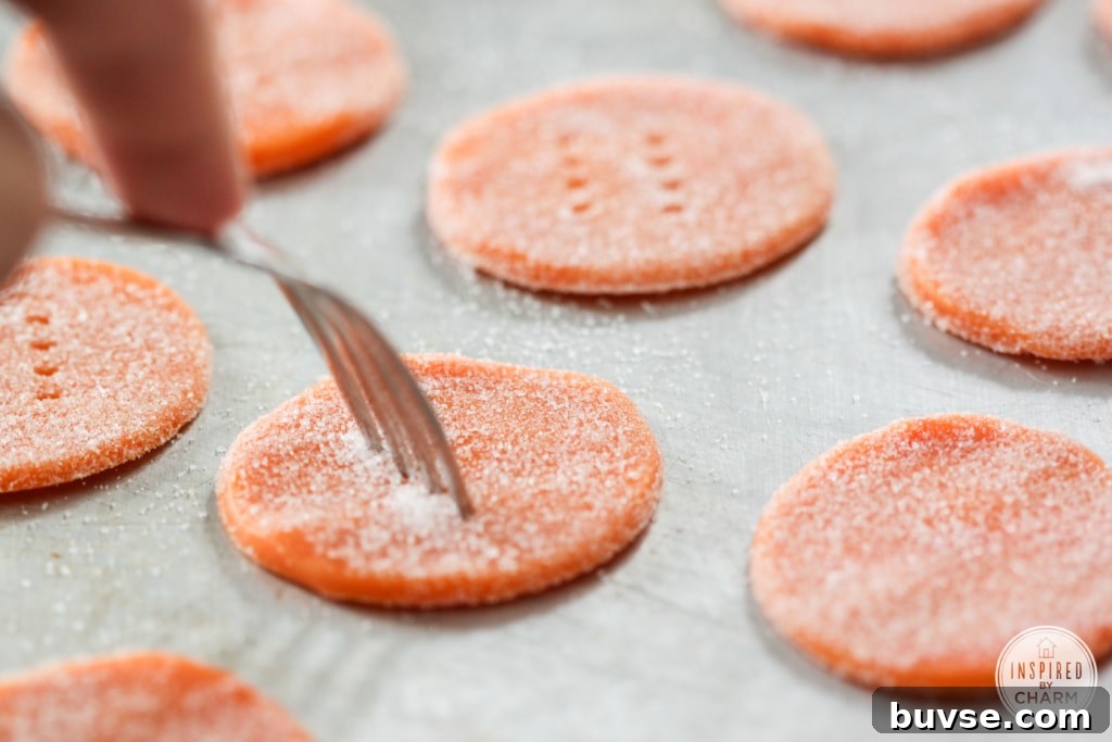 a fork piercing orange cookie dough coated with sugar.