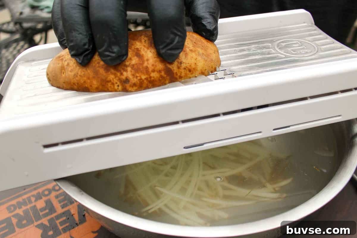 Slicing the potato into thin fries.