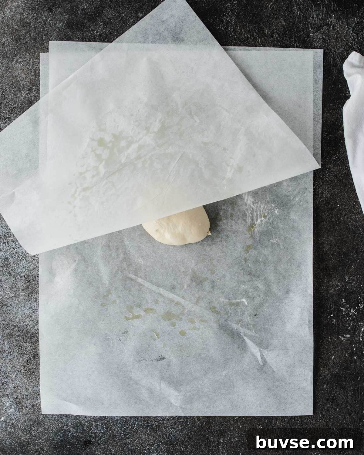 Homemade Garlic Pita Bread Recipe 8 Rolling out pita between parchment