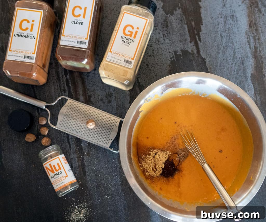 bowl of pumpkin pie custard surrounded by spices