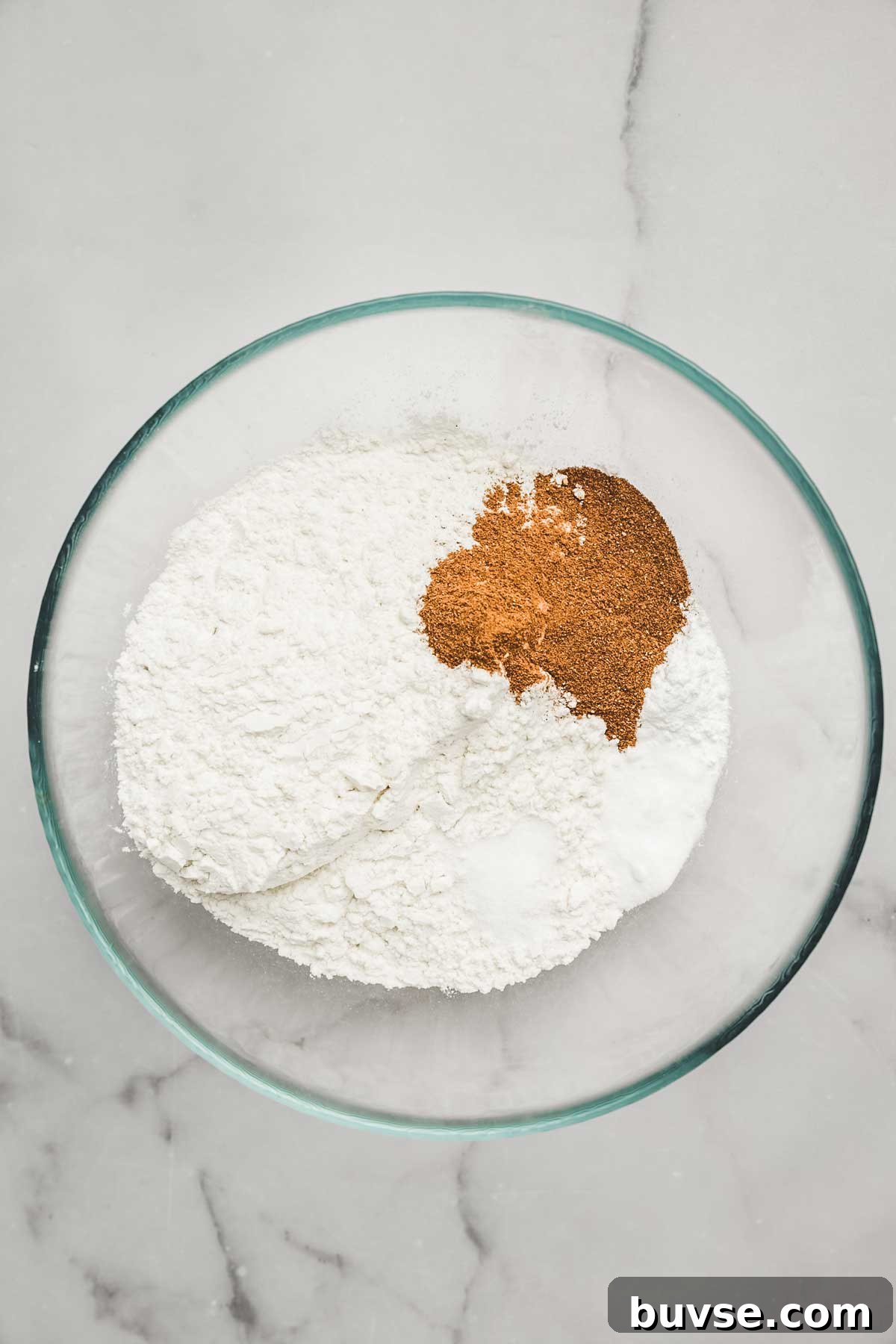 Dry ingredients for carrot cake cupcakes in a mixing bowl