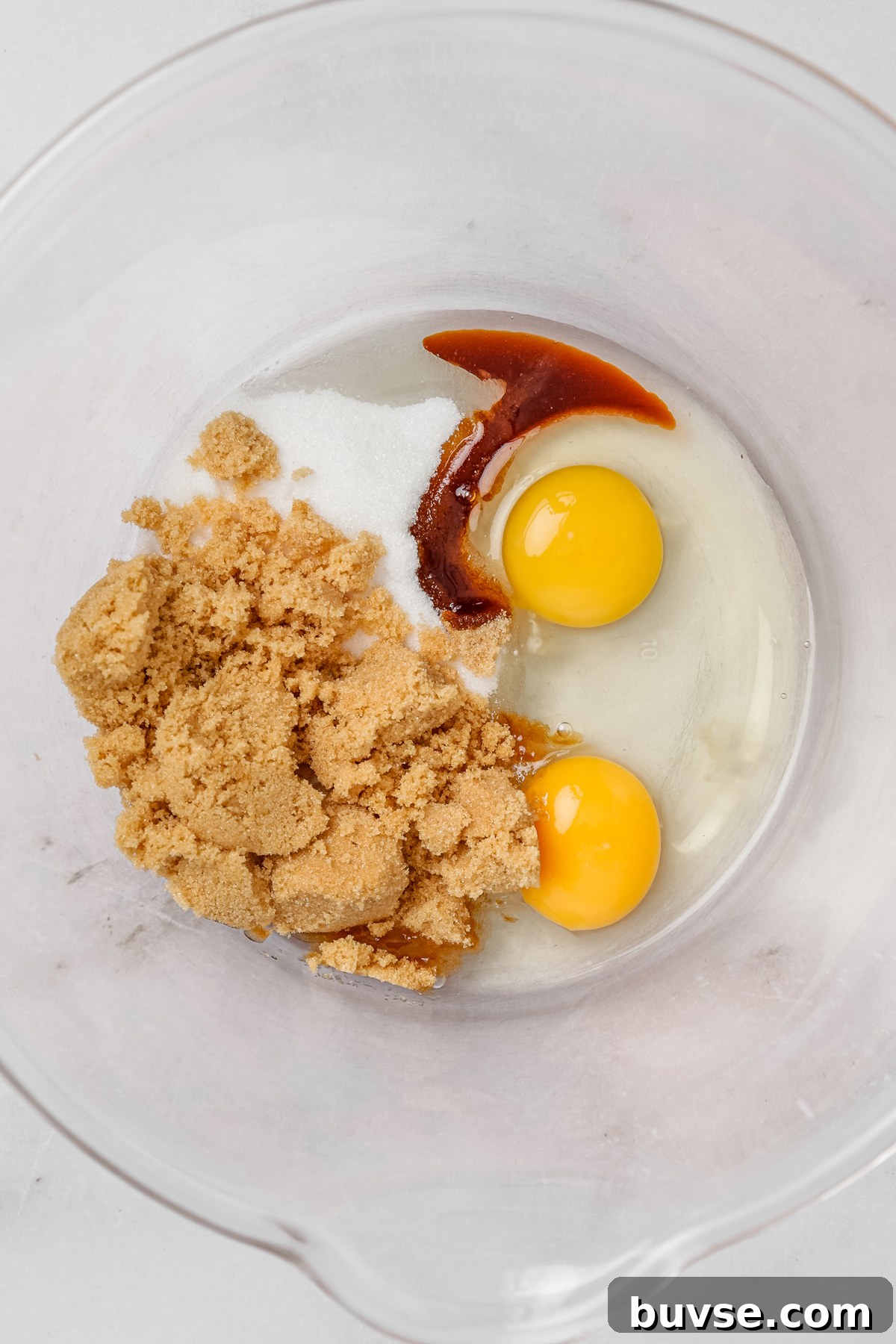 Wet ingredients for carrot cake cupcakes with sugar, eggs, and vanilla