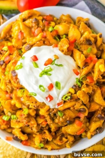 Overhead view of cheesy crockpot taco pasta made with ground beef, black beans, corn, and pasta.